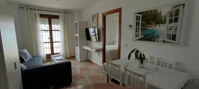 a living room with a table and a dining room at Apartamento atico Terraza Centro in El Puerto de Santa María