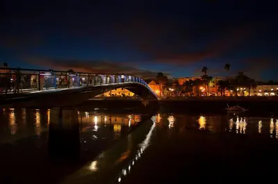 a train crossing a bridge over a river at night at Apartamento atico Terraza Centro in El Puerto de Santa María