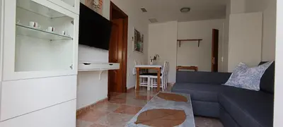 a living room with a blue couch and a kitchen at Apartamento atico Terraza Centro in El Puerto de Santa María