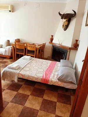 a bedroom with a bed and a table and chairs at Villa con piscina in Chiclana de la Frontera