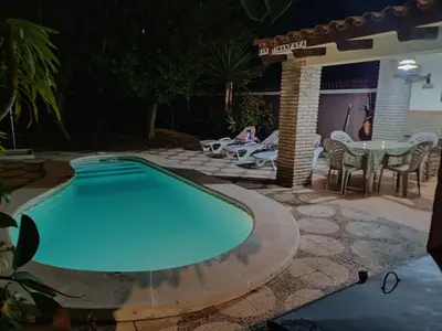a swimming pool in a backyard at night at Villa con piscina in Chiclana de la Frontera