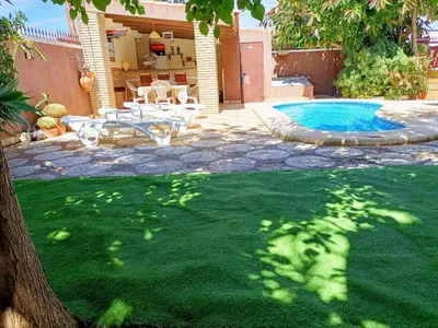 a yard with a pool and a table and a tree at Villa con piscina in Chiclana de la Frontera