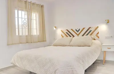 a white bedroom with a large bed and a window at Apartamento Rural Marisma in Hozanejos
