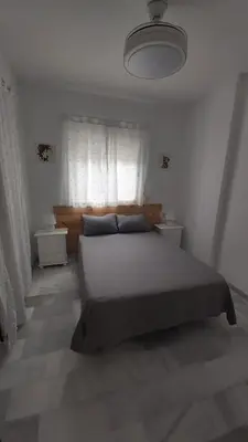 a bedroom with a large bed and a window at Brisas del Guadalquivir in Sanlúcar de Barrameda