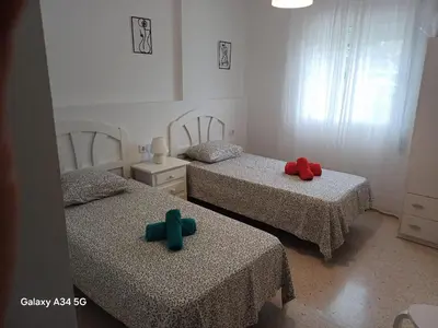 two beds in a room with two green and red pillows at Brisas del Guadalquivir in Sanlúcar de Barrameda