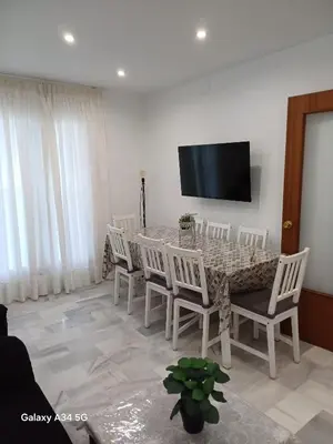 a dining room with a table and chairs and a television at Brisas del Guadalquivir in Sanlúcar de Barrameda