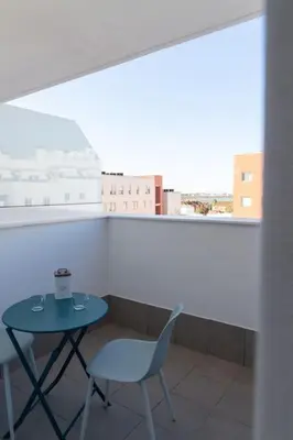 a table and chair in a room with a window at Las Salinas by Gades Gestión in Puerto Real