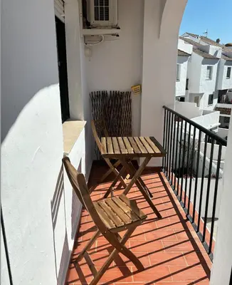 a balcony with two chairs and a table on a balcony at APARTAMENTO APARTACLUB REFORMADO in Chiclana de la Frontera