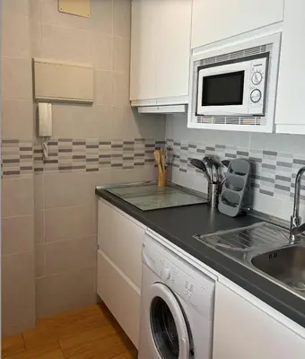 a kitchen with a sink and a washing machine at APARTAMENTO APARTACLUB REFORMADO in Chiclana de la Frontera