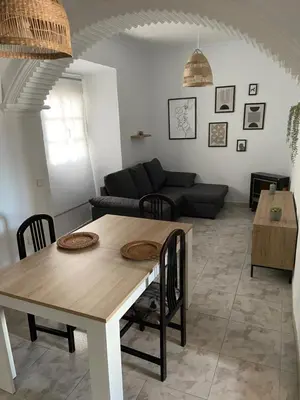 a living room with a table and a couch at Casa El Rincón de San Pedro in Arcos de la Frontera