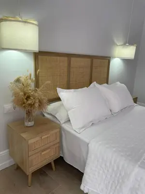 a bedroom with a bed and a table with a vase on it at Apartamento corredera 1 in Arcos de la Frontera