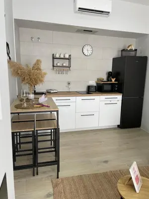a kitchen with white cabinets and a black refrigerator at Apartamento corredera 1 in Arcos de la Frontera
