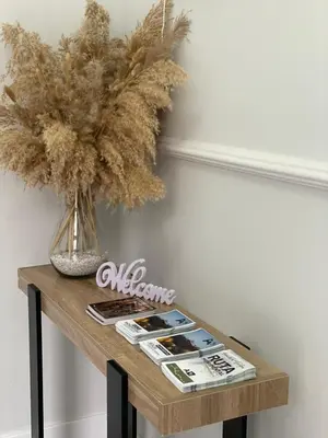 a table with a vase of flowers and magazines on it at Apartamento corredera 1 in Arcos de la Frontera