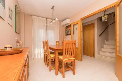 a kitchen with a wooden table and chairs at Rosamar in Chiclana de la Frontera
