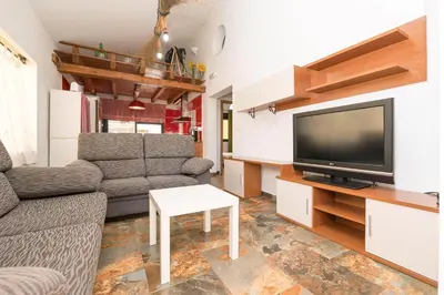a living room with a couch and a tv at Casa Amelie in Conil de la Frontera
