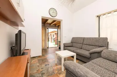a living room with a couch and a clock on the wall at Casa Amelie in Conil de la Frontera