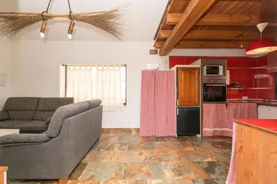 a living room with a couch and a kitchen at Casa Amelie in Conil de la Frontera