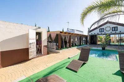 a resort with a pool and chairs and a building at Casa Amelie in Conil de la Frontera