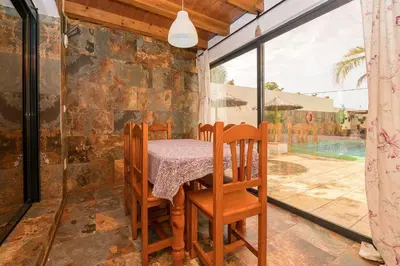 a dining room with a table and chairs on a patio at Casa Amelie in Conil de la Frontera