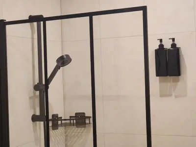 a shower with a glass door with a phone at Allo Apartments Caballeros II Centro 1 Habitación in Jerez de la Frontera