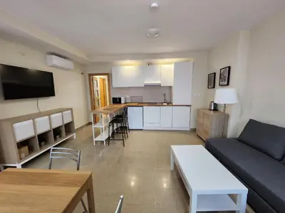a living room with a couch and a kitchen at Allo Apartments Caballeros II Centro 1 Habitación in Jerez de la Frontera
