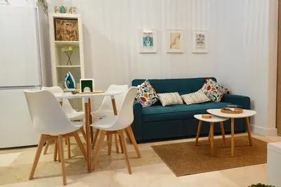 a living room with a blue couch and tables at Apartamento Langreo in Jerez de la Frontera