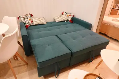 a green couch with pillows on it in a room at Apartamento Langreo in Jerez de la Frontera
