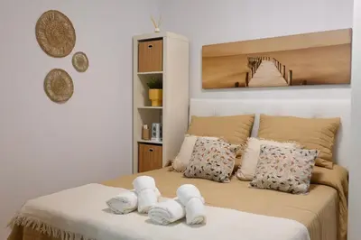 a bedroom with a bed with towels on it at Apartamento Langreo in Jerez de la Frontera