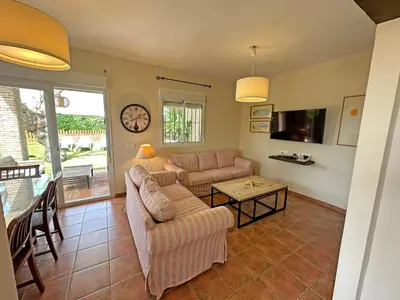 a living room with two couches and a table at Villa Buganvilla Conil - SOLO FAMILIAS in Conil de la Frontera