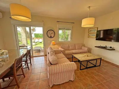 a living room with a couch and a table at Villa Buganvilla Conil - SOLO FAMILIAS in Conil de la Frontera