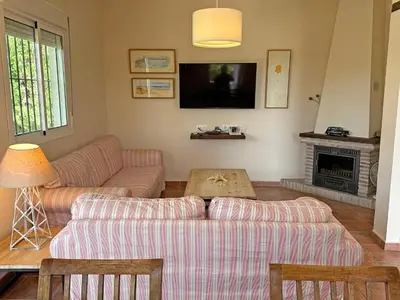 a living room with two couches and a tv at Villa Buganvilla Conil - SOLO FAMILIAS in Conil de la Frontera