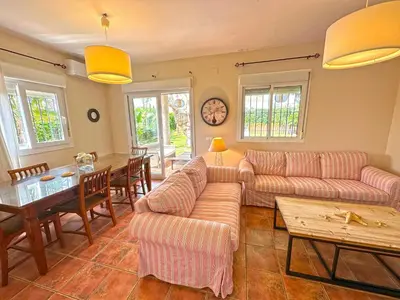 a living room with two couches and a table at Villa Buganvilla Conil - SOLO FAMILIAS in Conil de la Frontera