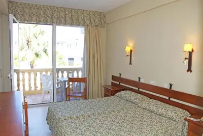 a hotel room with a bed and a balcony at Hotel Al Sur De Chipiona by YouRoom in Chipiona