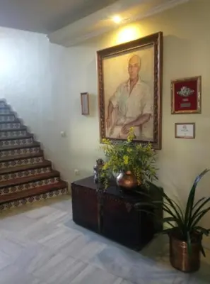 a painting of a man on a wall next to a staircase at Hotel Al Sur De Chipiona by YouRoom in Chipiona