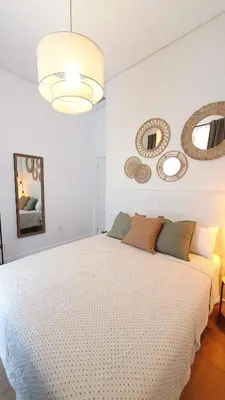 a bedroom with a white bed and mirrors on the wall at Casa Porvenir in Jerez de la Frontera