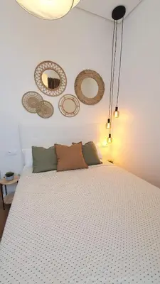 a bedroom with a large white bed with decorations on the wall at Casa Porvenir in Jerez de la Frontera