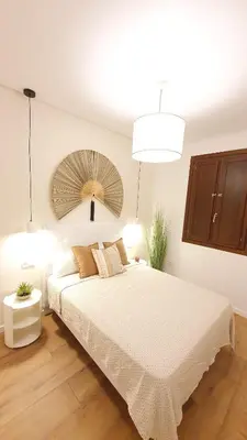 a bedroom with a large white bed and a mirror at Casa Porvenir in Jerez de la Frontera