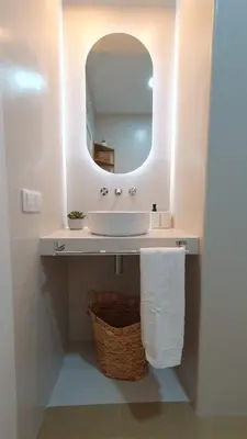 a bathroom with a sink with a mirror and a basket at Casa Porvenir in Jerez de la Frontera