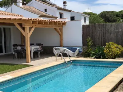 a swimming pool with a pergola next to a house at Villas Dehesa Roche Viejo in Conil de la Frontera