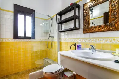 a bathroom with a sink and a toilet and a mirror at Villas Dehesa Roche Viejo in Conil de la Frontera