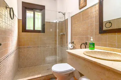a bathroom with a shower and a toilet and a sink at Villas Dehesa Roche Viejo in Conil de la Frontera
