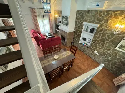 a living room with a red couch and a table at Villas Dehesa Roche Viejo in Conil de la Frontera