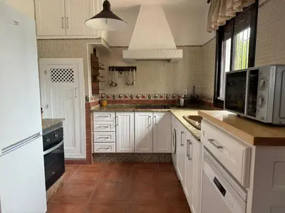 a kitchen with white cabinets and white appliances at Villas Dehesa Roche Viejo in Conil de la Frontera