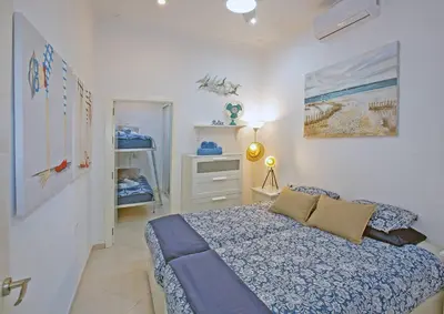 a bedroom with a bed and a dresser in it at Cadizz - El Faro del Manteca - Terraza privada barrio de la Viña - La Caleta in Cádiz