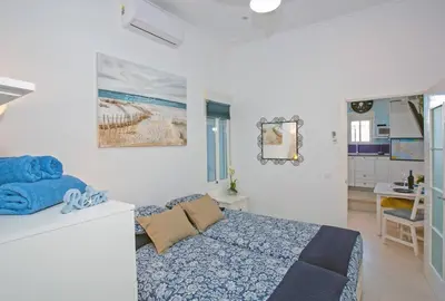 a white bedroom with a bed and a bathroom at Cadizz - El Faro del Manteca - Terraza privada barrio de la Viña - La Caleta in Cádiz