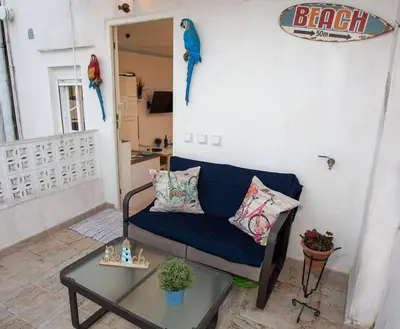 a living room with a blue couch and a table at Cadizz - El Faro del Manteca - Terraza privada barrio de la Viña - La Caleta in Cádiz