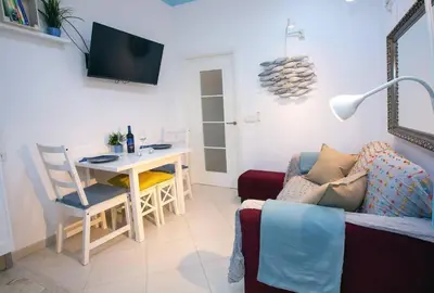 a living room with a couch and a table and a desk at Cadizz - El Faro del Manteca - Terraza privada barrio de la Viña - La Caleta in Cádiz