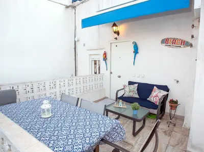 a patio with a table and a blue table and chairs at Cadizz - El Faro del Manteca - Terraza privada barrio de la Viña - La Caleta in Cádiz
