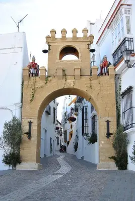 a building with an arch over a street at Casa con vistas en Arcos in Arcos de la Frontera