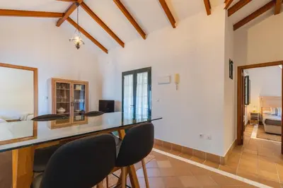 a kitchen and living room with a counter and chairs at Encantador piso Plaza Rivero in Jerez de la Frontera